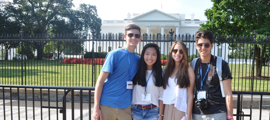 students posing for a photo in front of the fence at the white house