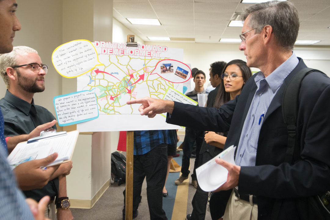 Students in the Brasilia Without Borders program sharing poster project with professor
